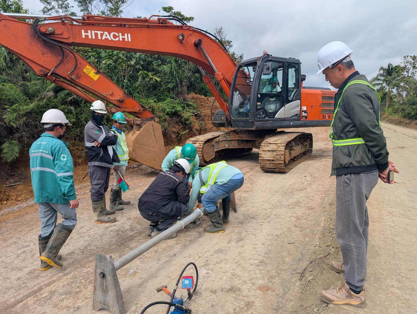 Excavator and crew at road construction site
