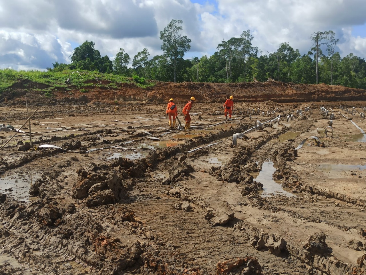 Workers managing challenging soil conditions before treatment